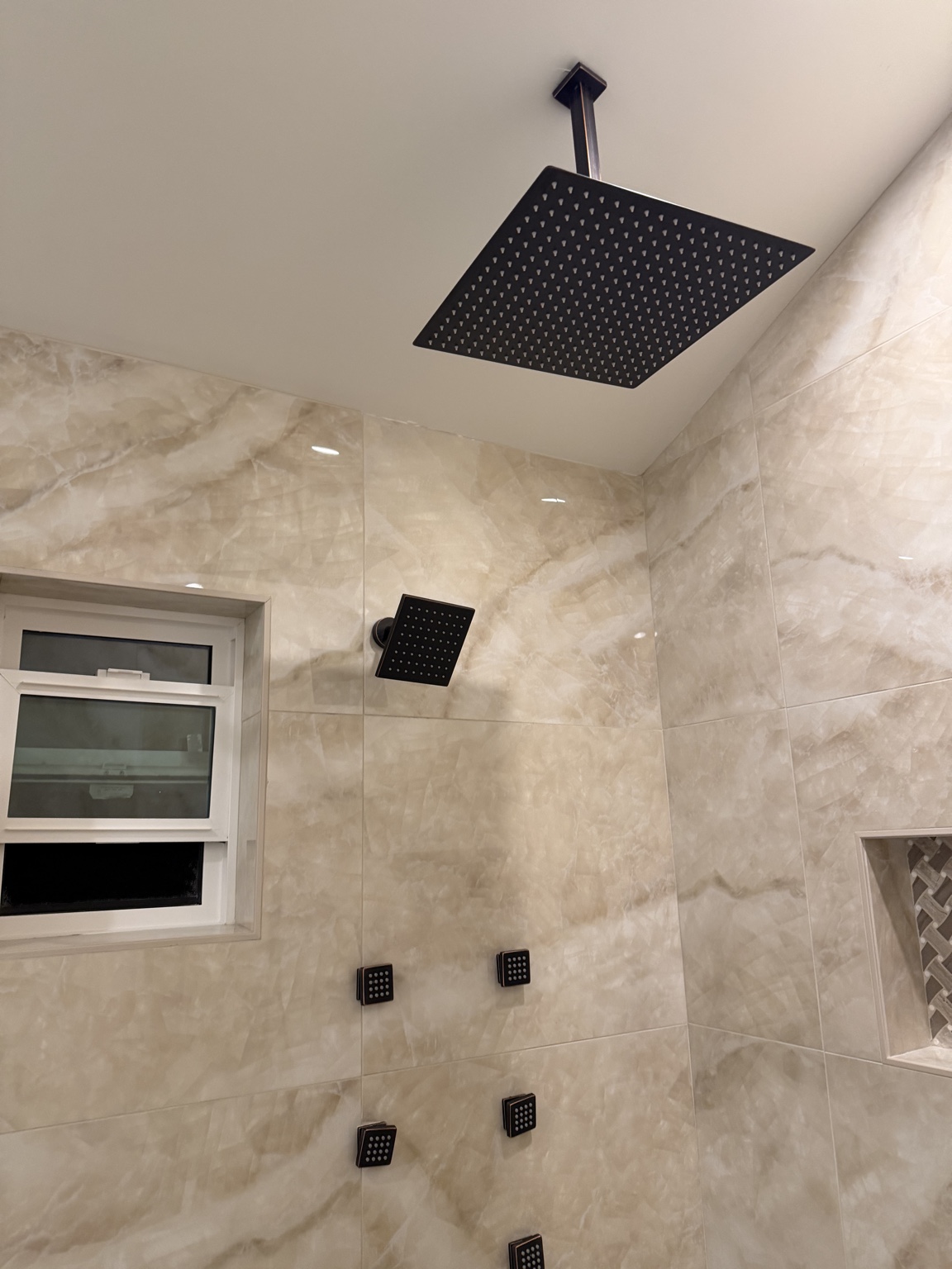 Large rain shower head and body jets with black fixtures